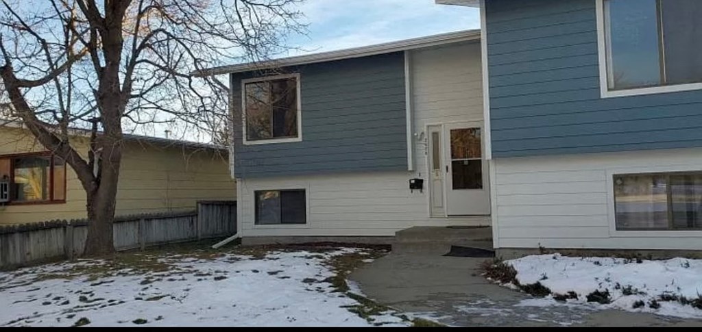 a white and blue house with snow on the ground