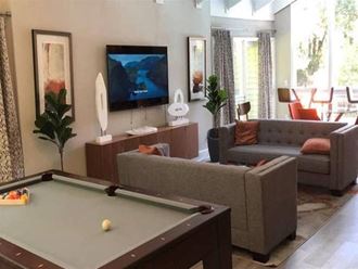 a living room with a pool table and a tv