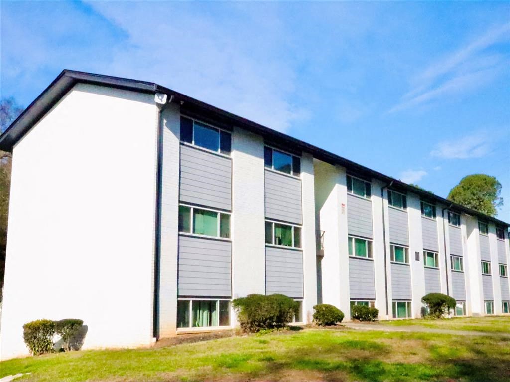 a white building with a brown roof at Uphill Flats, Decatur, GA, 30032