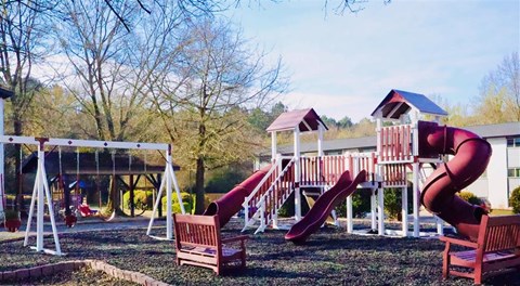 a playground with a swing set and a tree at Uphill Flats, Decatur, 30032