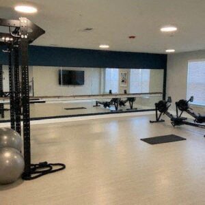 a fitness room with weights and a mirror
