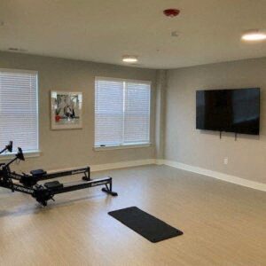 a workout room with a reformer and a tv on the wall