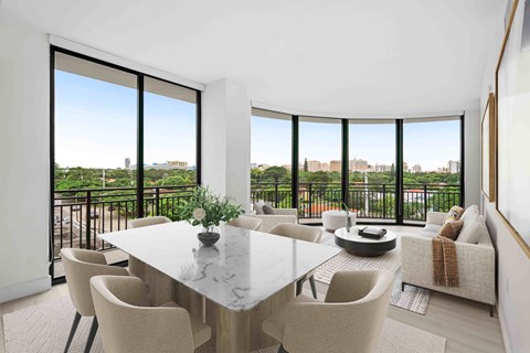 A dining room with a table and chairs and a view of the city.