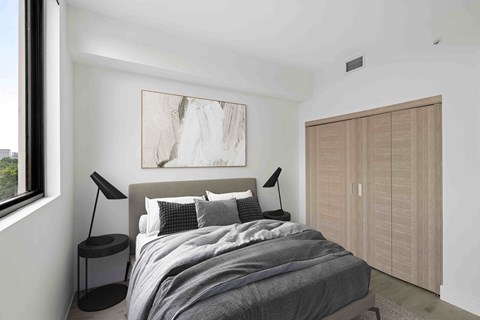 A bedroom with a large bed and a painting on the wall.
