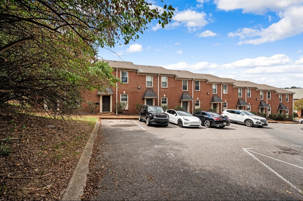 A parking lot with cars and a building in the background.