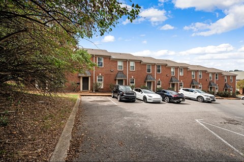 A parking lot with cars and a building in the background.