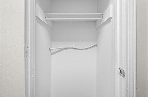 Empty white shelves in a white door.