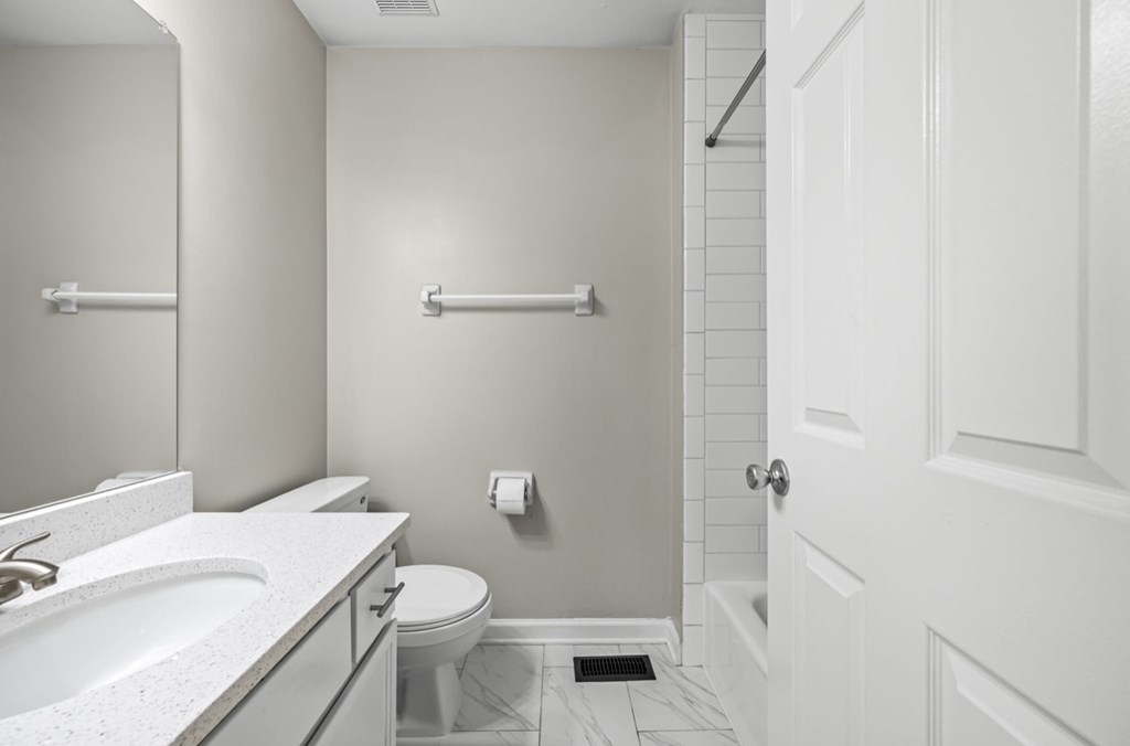 A white bathroom with a toilet, sink, and a door.