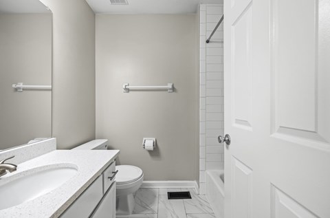 A white bathroom with a toilet, sink, and a door.