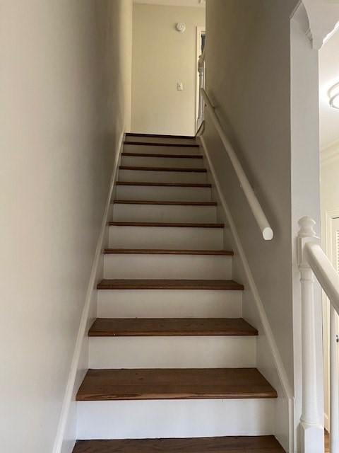 A staircase with white walls and wooden steps.