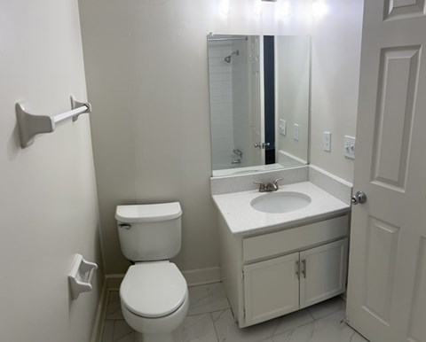 A white toilet and sink in a bathroom.