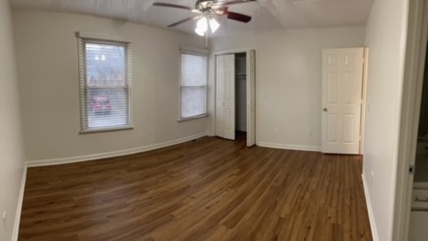 A room with wooden floors and a ceiling fan.