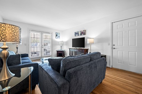 A living room with a grey couch and a black and white lamp.