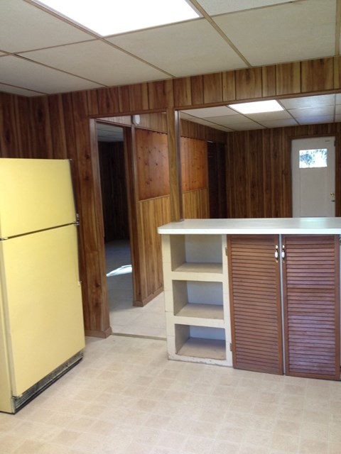 an empty kitchen with a yellow refrigerator and shelves