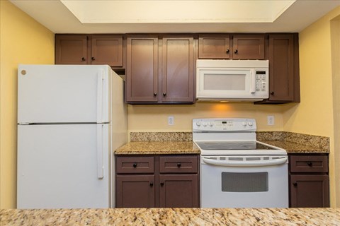 a kitchen with white appliances and granite counter tops