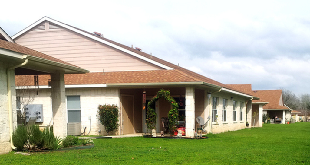 a house with a porch and a green lawn