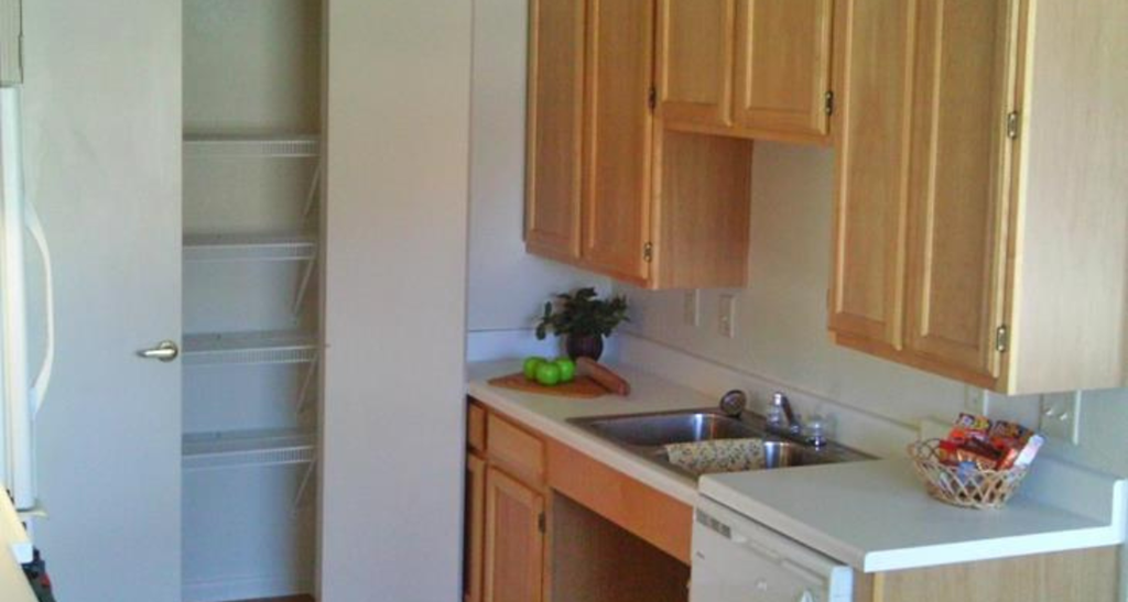 a small kitchen with wooden cabinets and a sink