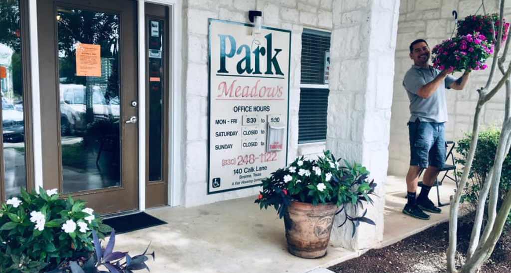 a man holding a bunch of flowers in front of a building