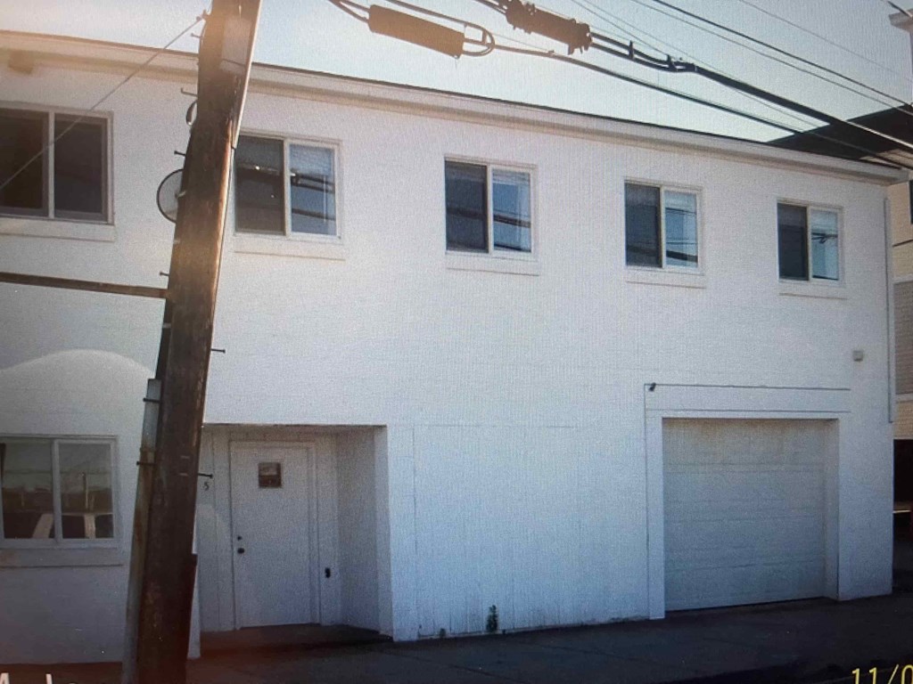 A white building with a closed garage door.