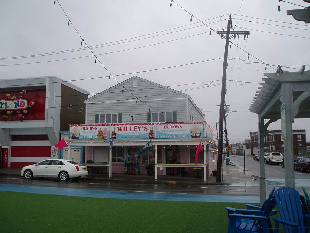 A car is parked in front of a building with a sign that says "Our Own Willey's".