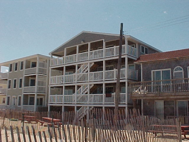 a beach house with a wooden fence in front of it