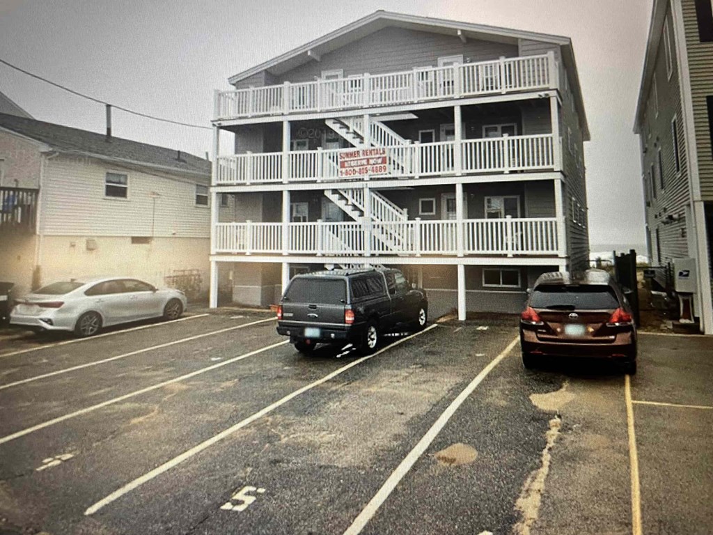 a beach house with cars parked in front of it