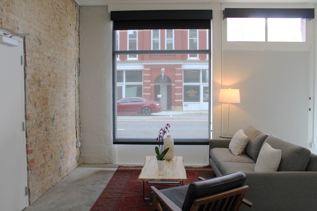 a living room with a large window and a couch and a coffee table