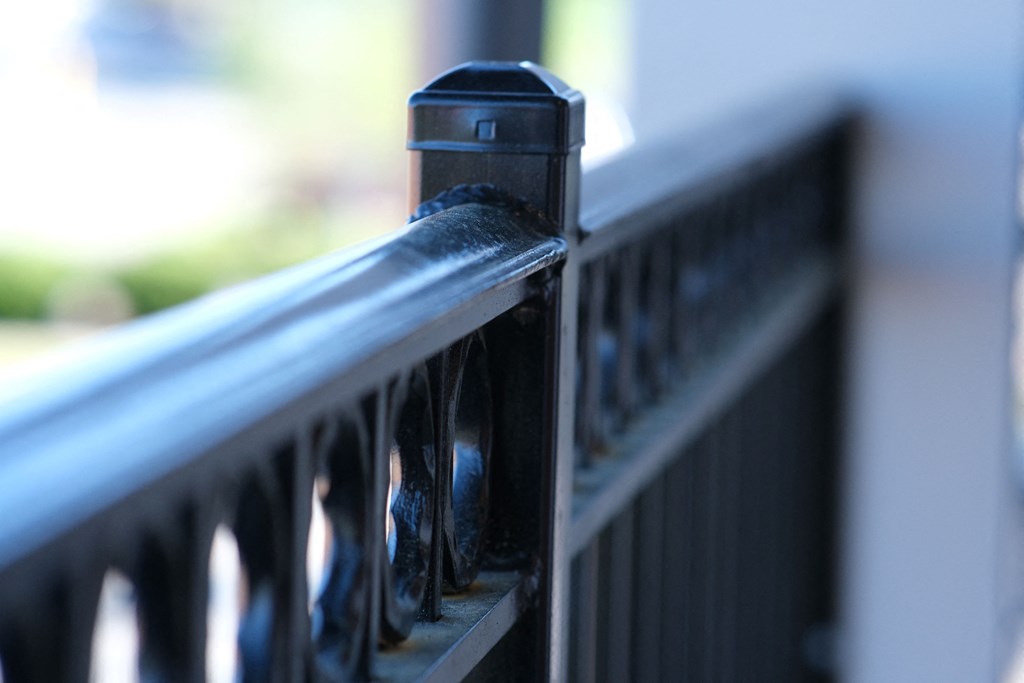 a black iron railing with a metal post