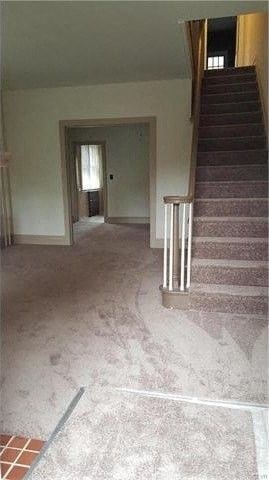 a living room with a staircase and a hallway with stairs