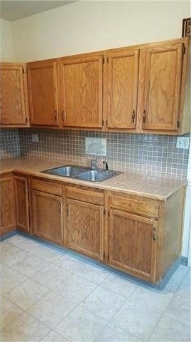 an empty kitchen with wooden cabinets and a sink