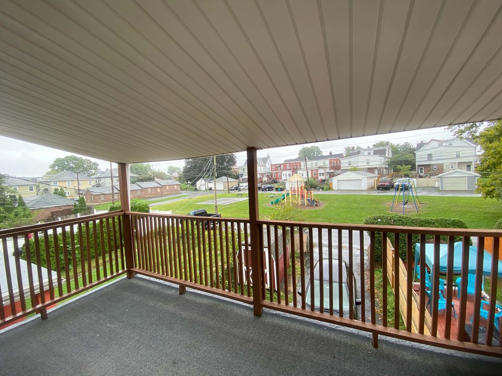 a porch with a view of a playground and a pool
