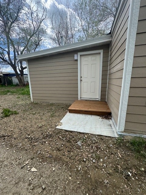 A small house with a white door and a brown mat in front of it.
