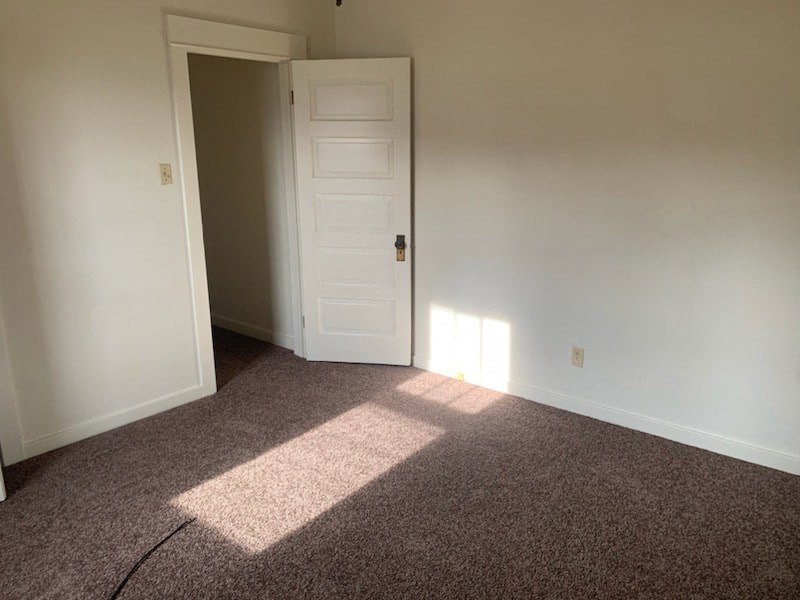 a room with a carpeted floor and a white door