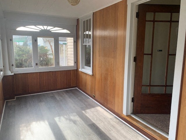 an empty room with wood paneling and a window