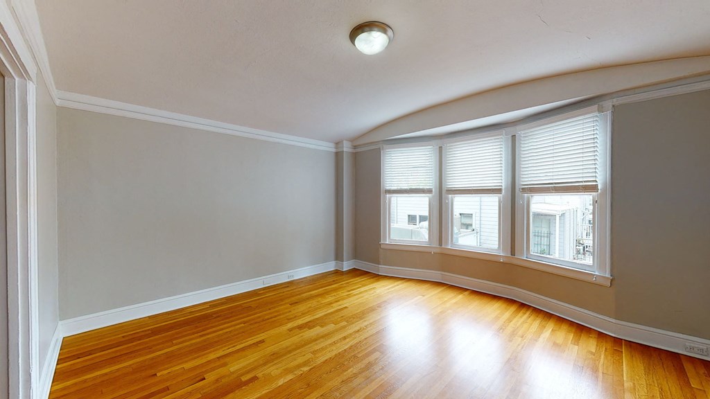 an empty living room with wood floors and windows