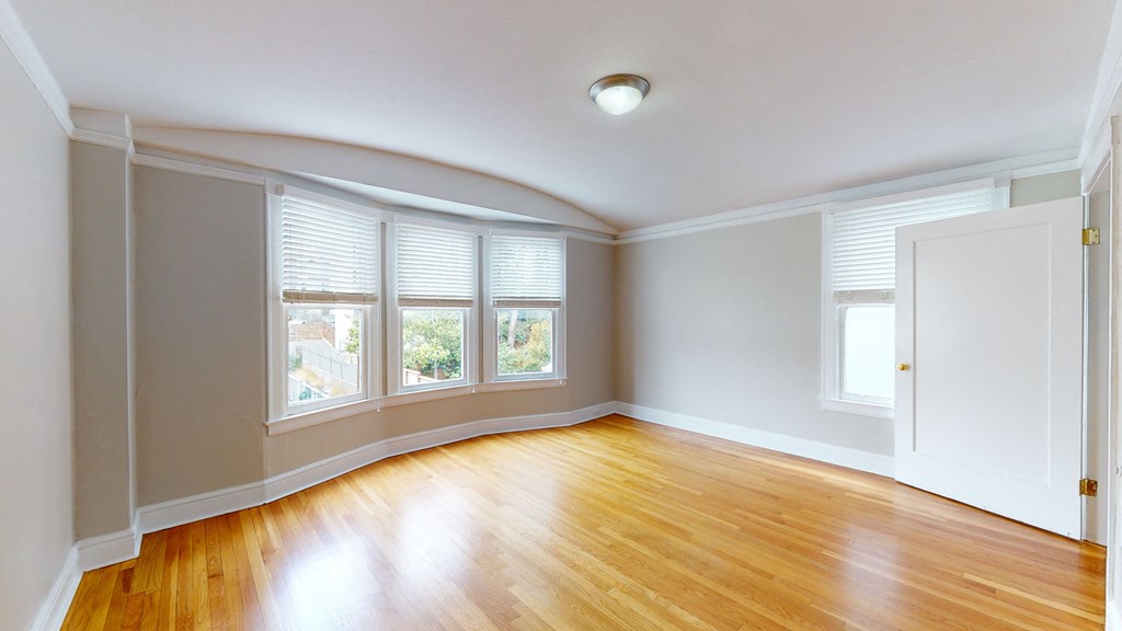 an empty living room with wood floors and windows