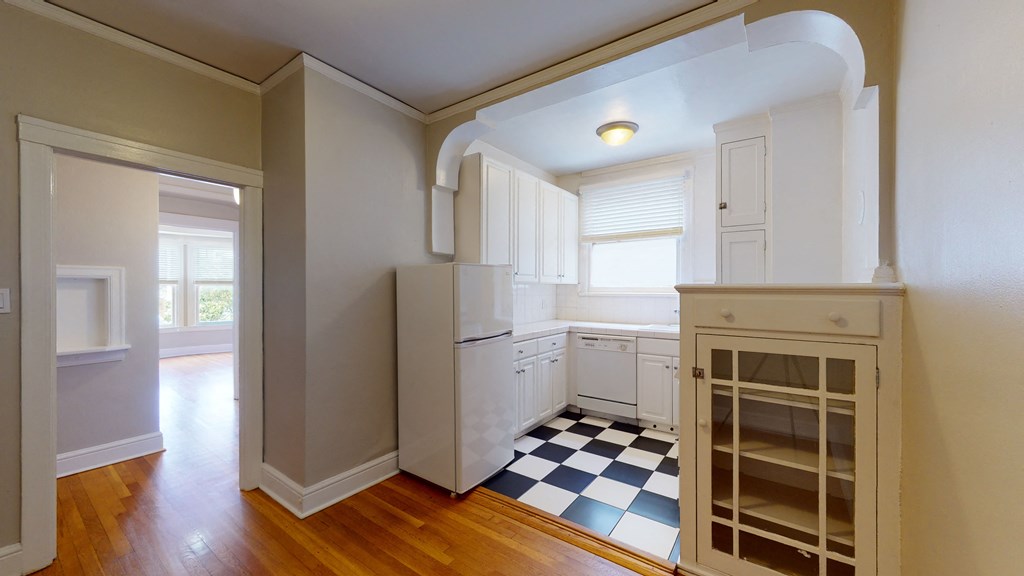 a kitchen with a checkered floor and a white refrigerator