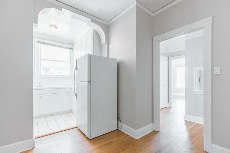 an empty room with a refrigerator in the middle of it