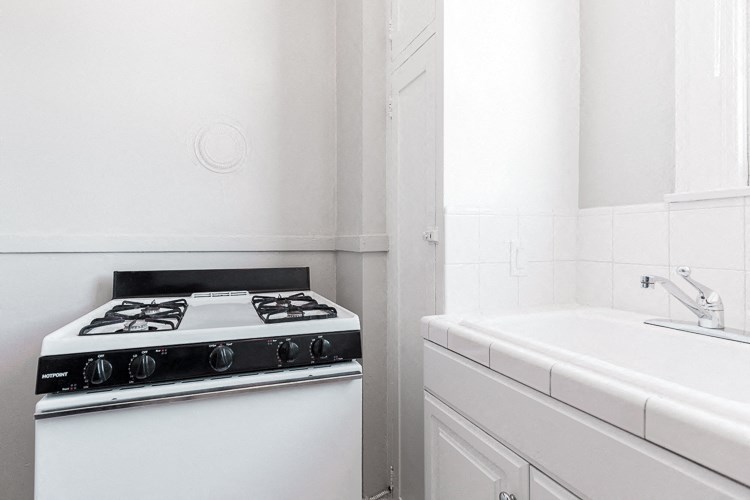 a white kitchen with a stove and a sink