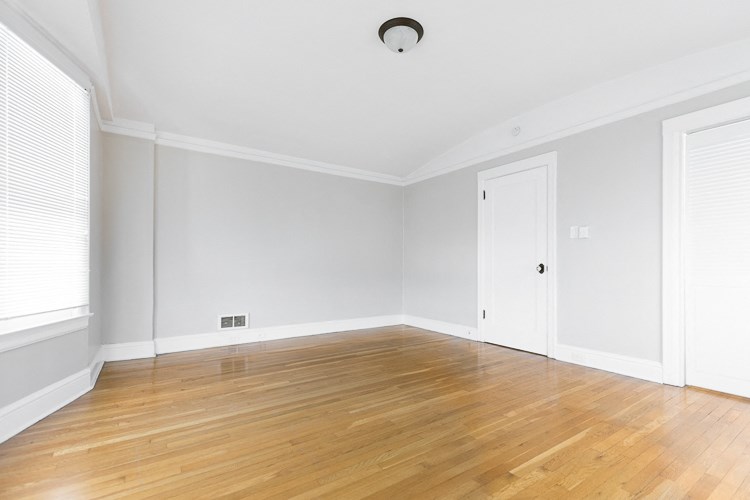 an empty living room with wood floors and white walls