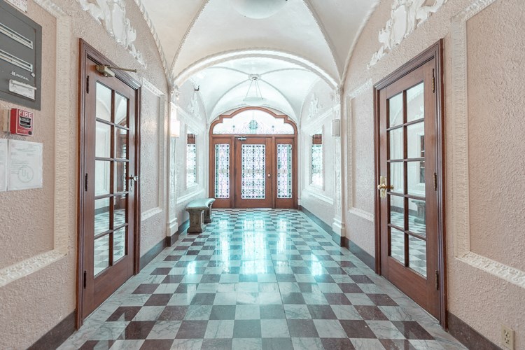 the lobby of a building with a checkered floor and doors