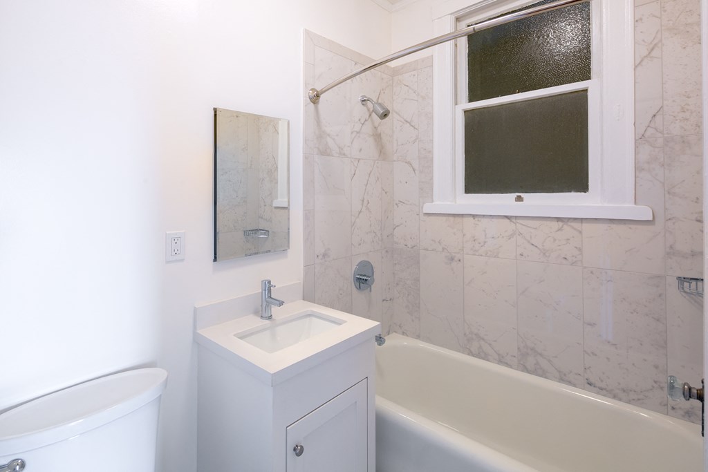 a bathroom with a sink and a bath tub and a window
