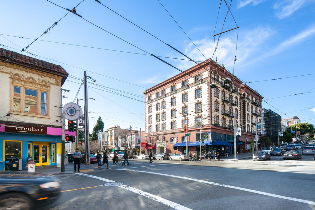 a busy city street with cars and pedestrians on a cross walk
