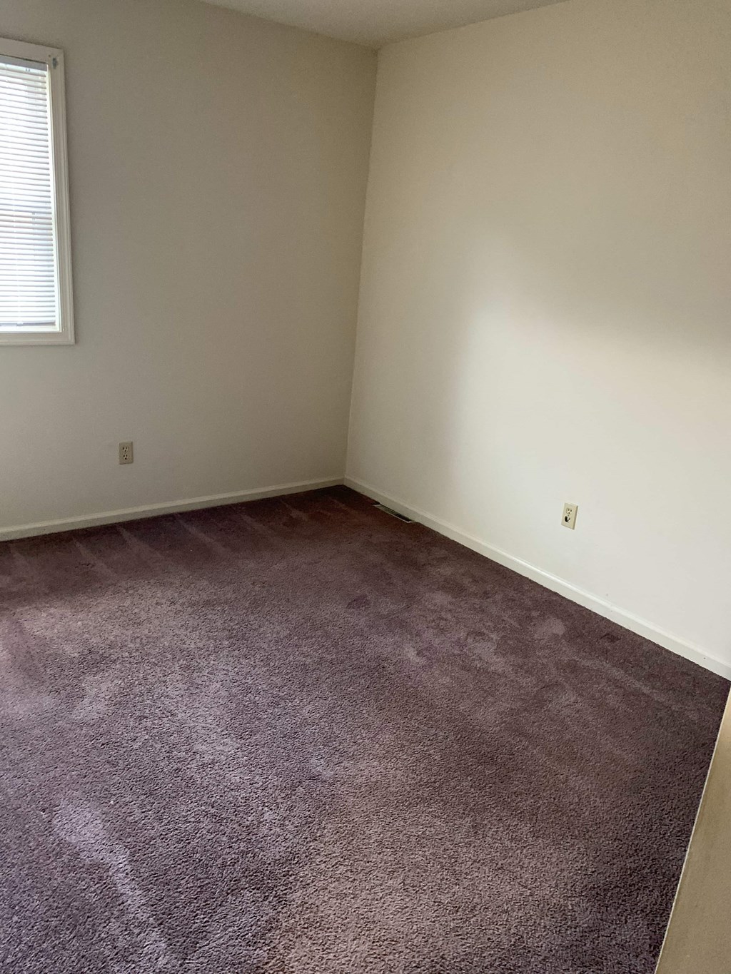 a room with a carpeted floor and a window