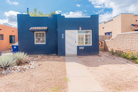 a blue house with a white door and a sidewalk