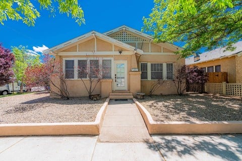 the front of a house with a sidewalk and trees