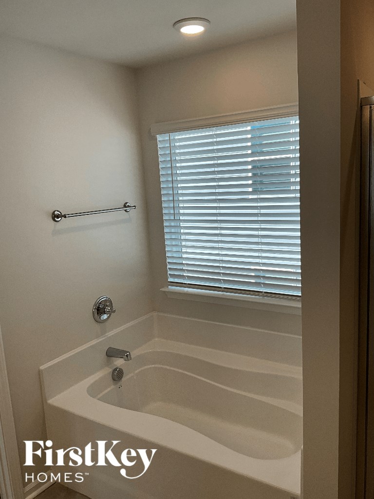 a small bathroom with a tub and a window