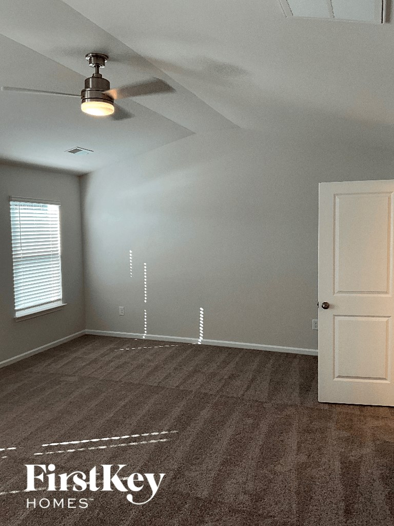 an empty room with a door and a ceiling fan