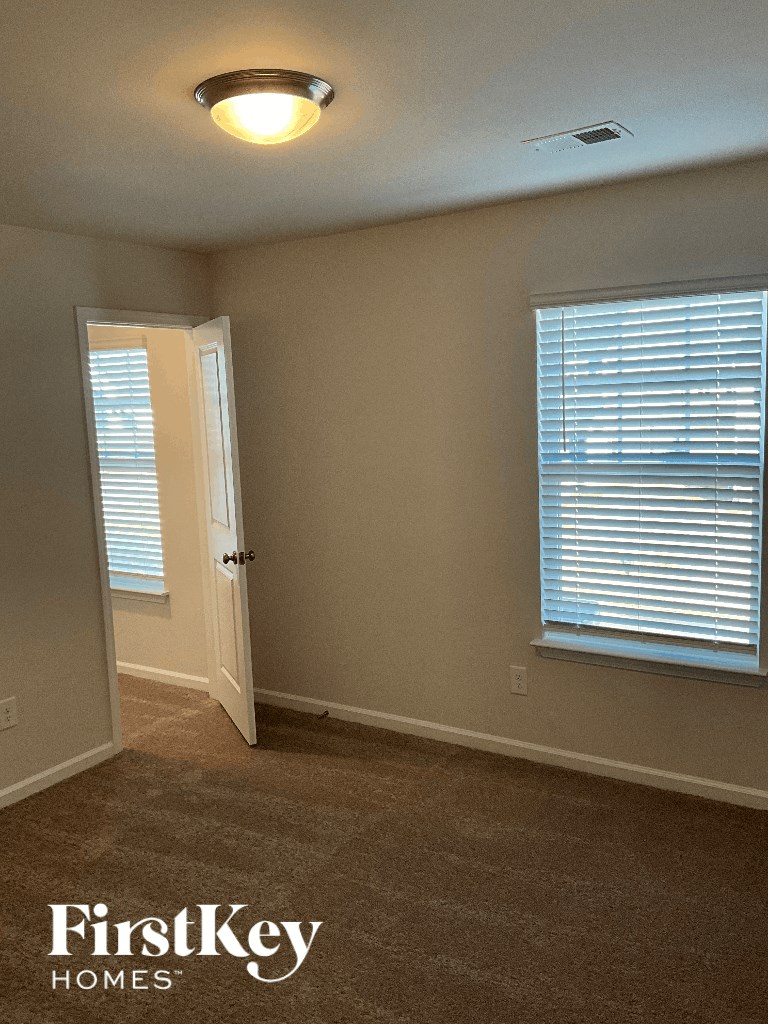 a small room with a door and a window and a door to a closet