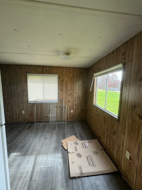 A room with wooden walls and a window with blinds.